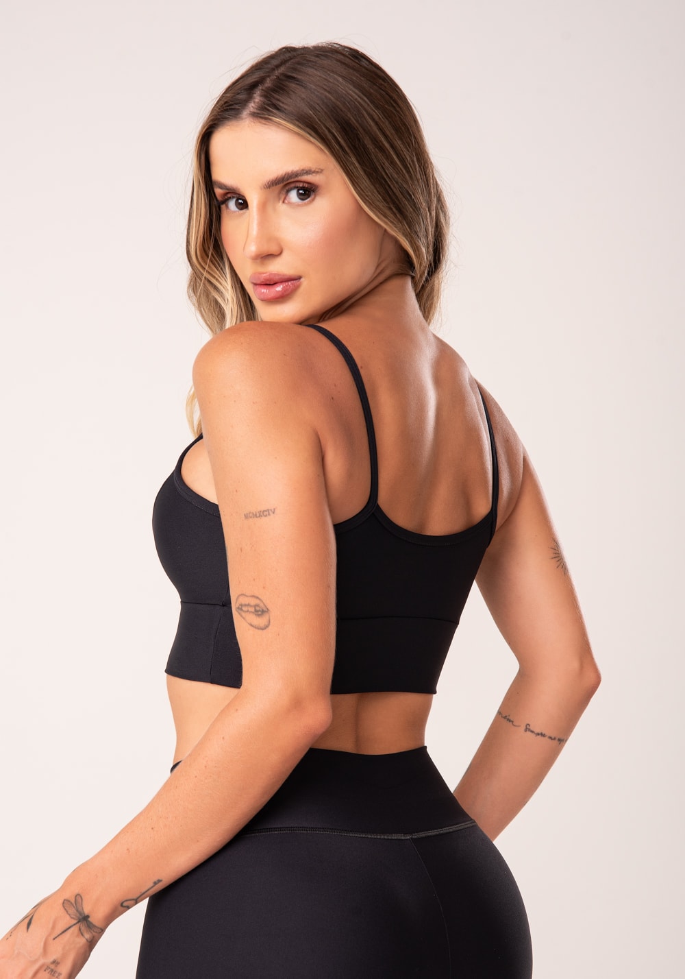 Top fitness preto com recortes e bojo básico
