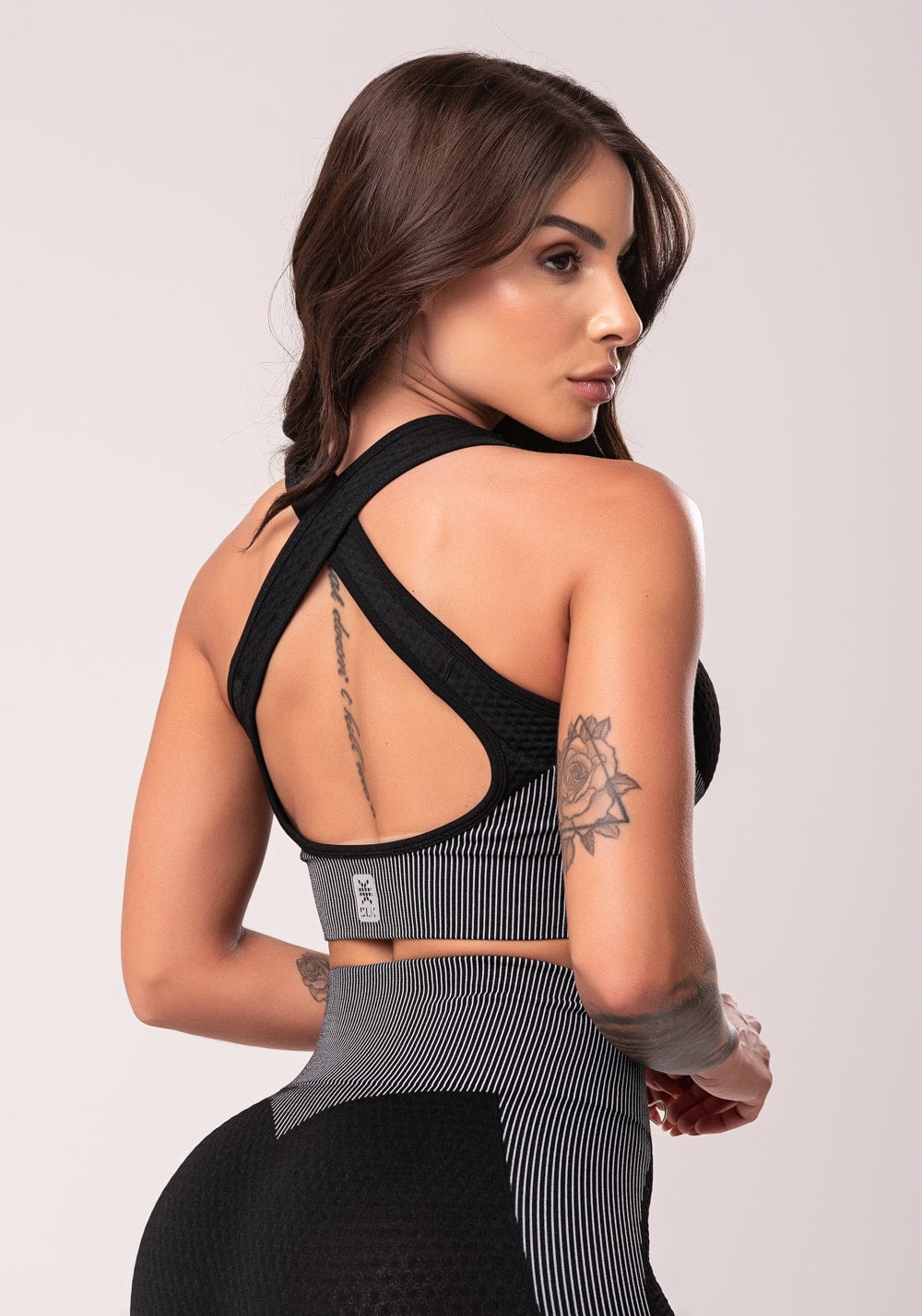 Top fitness feminino preto texturizado com bojo e alças cruzadas seamless