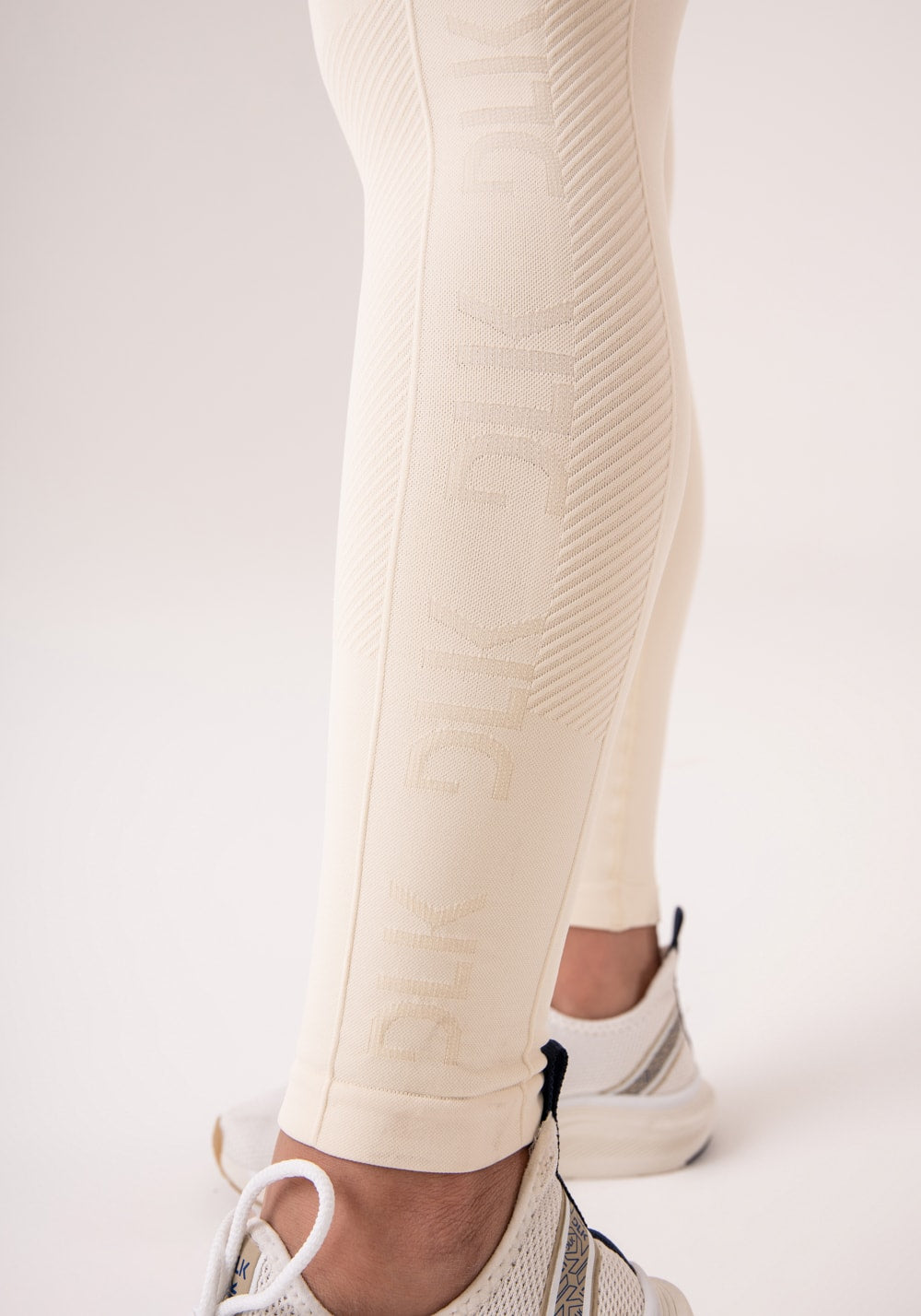 Legging fitness feminina creme com detalhe logomania e modela bumbum seamless+